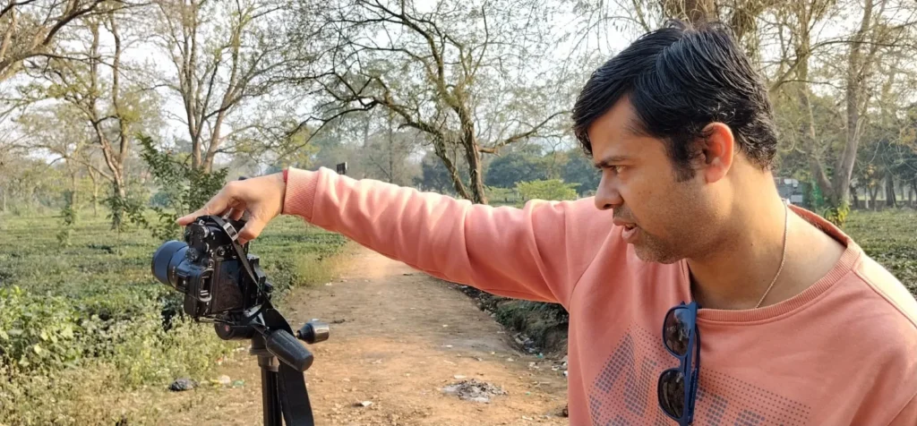 Behind the scenes: director framing a shot in an Assam tea garden